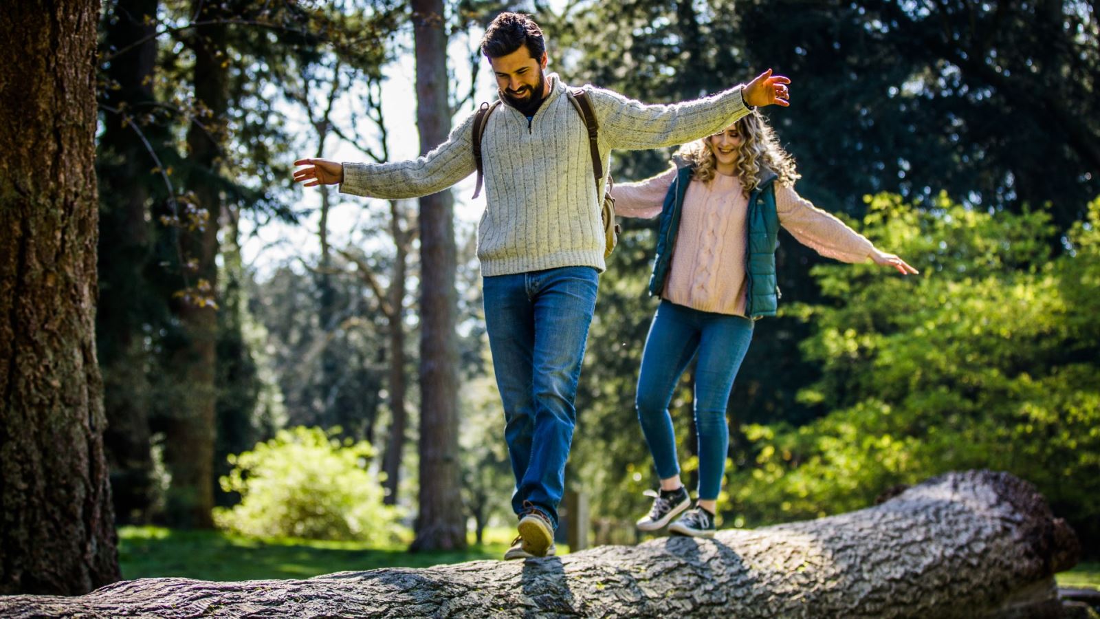 Man and woman walk along at log at Westonbirt